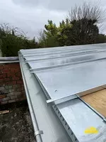 Bac joint debout et gouttière installés sur une toiture pour l'évacuation des eaux de pluie.