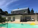 Bac terrasse à tasseaux en zinc installé sur le toit d' une maison avec vue sur la piscine.