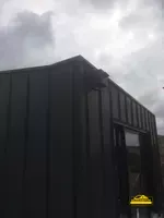 Bardage en zinc couleur quartz sur la façade d' une maison pour une isolation et une finition esthétique.