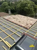 Début de la pose de tuiles sur la toiture pour une couverture solide.