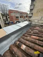 Installation d'un chéneau en zinc avec acrotère sur une maison ancienne, assurant l'évacuation des eaux tout en préservant le charme du bâtiment.