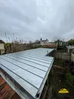 Installation de bac en joint debout en zinc couleur naturelle sur une maison en construction.