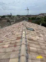 Bande de faîtage à sec avec closoire ventilé en plomb installée autour d'un Velux sur la toiture pour une étanchéité optimale.