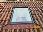 Pose d'une fenêtre de toit Velux sur une toiture ancienne.