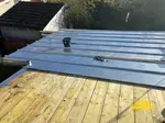 Commencement des travaux de pose des bac en joint debout avec support en volige vue de côté.