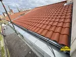 Toiture en tuile avec gouttière en zinc pour une finition durable avec entablement à coulisso.