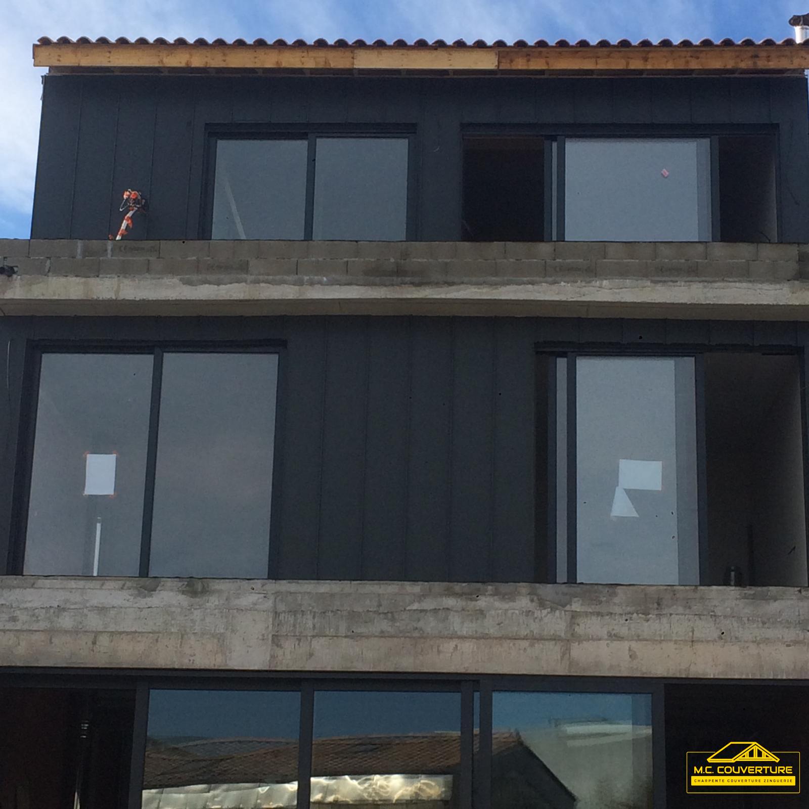 Réalisation de bardage en zinc sur une façade, ajoutant une touche moderne et durable à l'architecture extérieure du bâtiment.